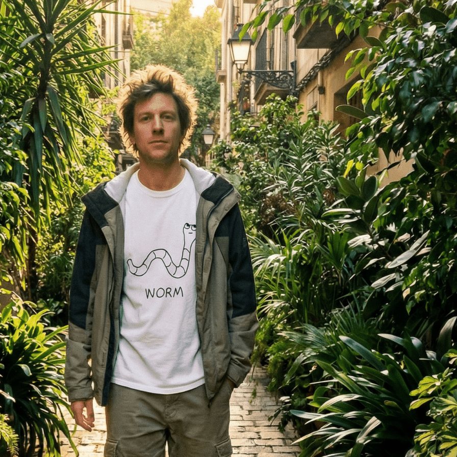 Man walking a plant-lined alley wearing a lo-fi Worm Classic Tee
