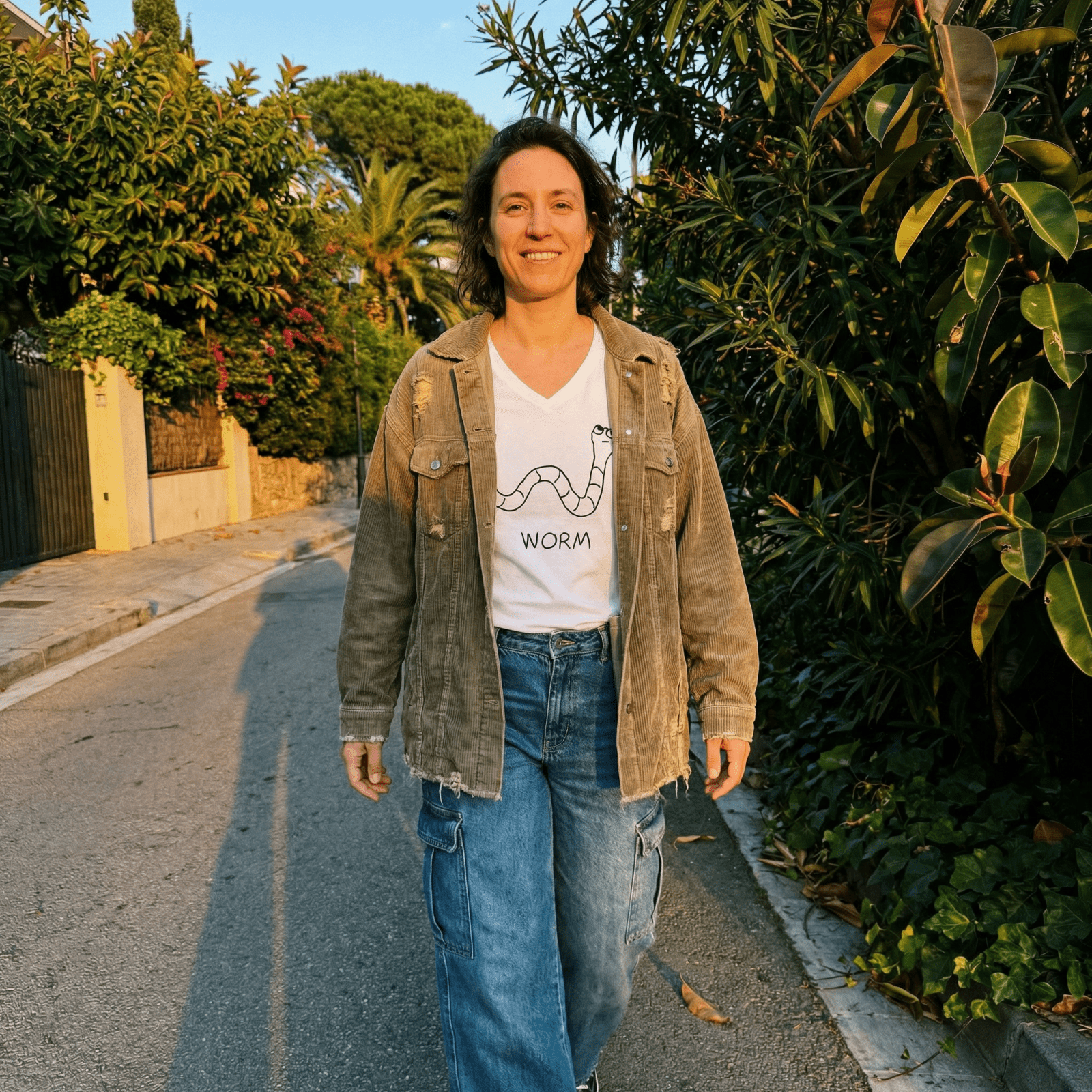 Woman on a Mediterranean garden lane wearing a lo-fi Worm V-Neck T-Shirt
