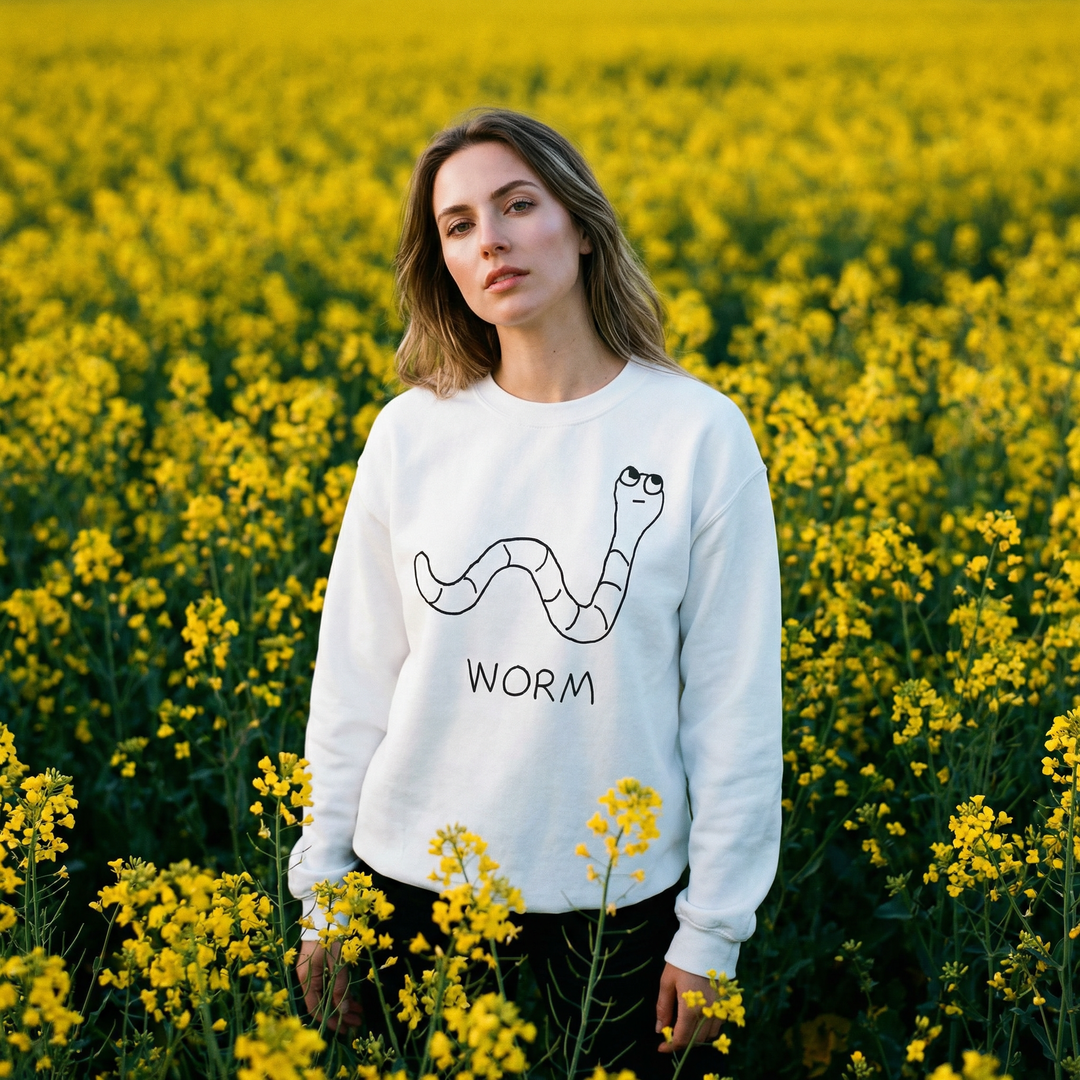 Model in a worm sweatshirt standing in a flower field, face to camera, perfectly content