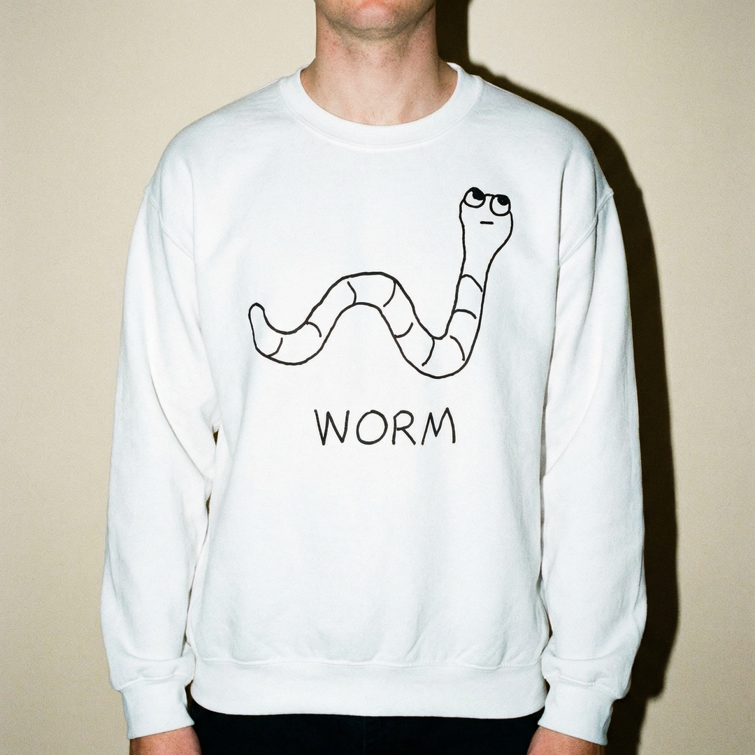 Model in a worm sweatshirt against an earthy beige background, low-key and comfortable