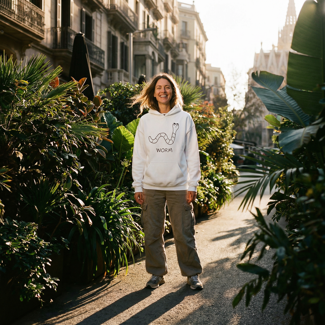 Woman wearing Worm hoodie on a Barcelona street surrounded by green plants – quirky animal graphic hoodie